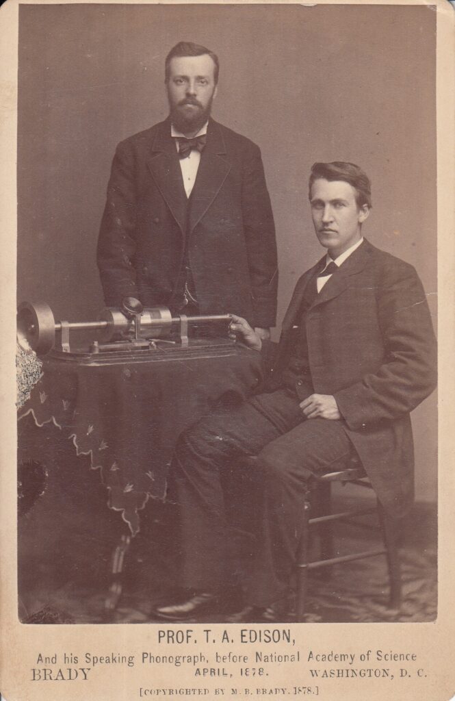 Thomas Edison and Charles Batchelor demonstrating the tinfoil phonograph in 1878