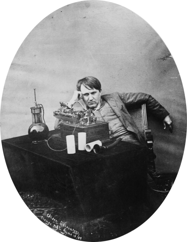 Thomas Edison listening through tubes to a wax-cylinder phonograph in 1888
